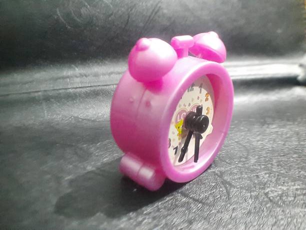 Pink toy table clock: cute, compact, whimsical, accurate, portable, charming, vibrant, stylish, functional.