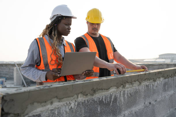 istock Worker engineer African woman use notebook computer working with caucasian worker at construction site 2137251608