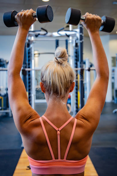 istock Woman working out at a gym.  Using weights and gym equipment 2137289721