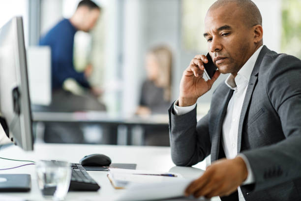 istock Black businessman talking on cell phone in the office. 2137303257