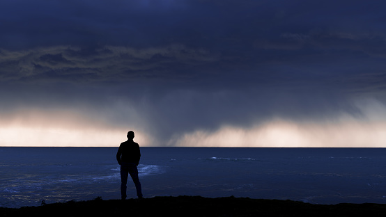 Weather. Man looking at the storm coming in from the sea.