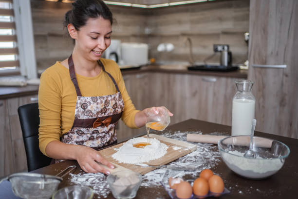 istock Smiling brunette woman making fresh dough in the kitchen 2137312300