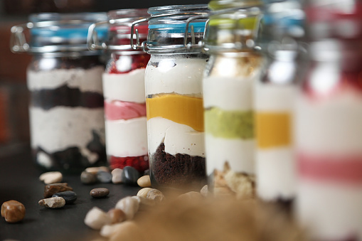 A row of glass jars filled with a variety of food items, showcasing a diverse selection of ingredients and flavors.