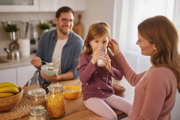 istock Happy family having breakfast at table in kitchen 2137332381