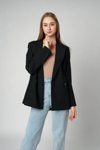 istock Young Woman Wearing Black Jacket and Jeans posing on gray background studio shot . 2137338230
