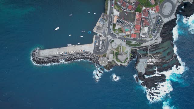 Stunning Porto Montiz aerial view looking down at natural turquoise coastal pools of the Madeira waterfront resort