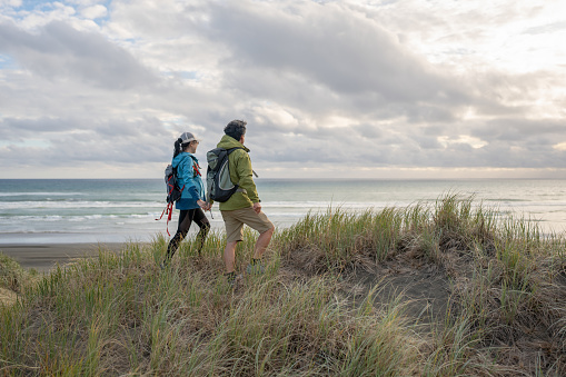 A senior Asian couple hiking along the west coast of New Zealand