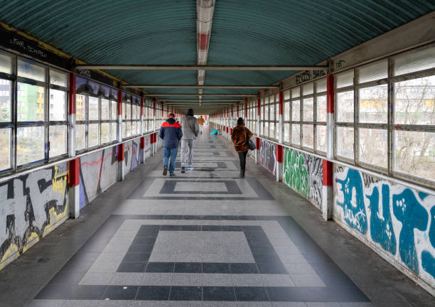 Germany, Berlin, March 17, 2024 -Rear view of people walking on pedestrian bridge, Berlin Subway station Storkow