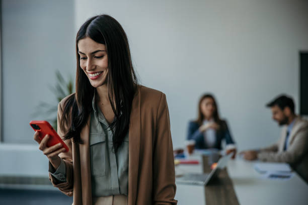istock Smiling businesswoman texting in the office 2137383597