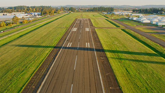 Aerial view of airport runway of small airport midst grassland on sunny day, Oregon, USA.