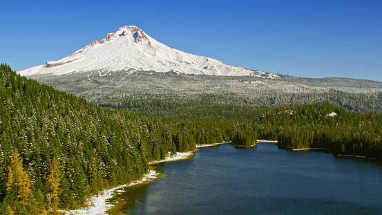 Aerial view of a lake beneath with Mt. Hood covered snow peak shining in background , Oregon, USA