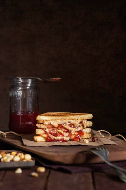 Grilled peanut butter and strawberry  jelly sandwich on a rustic background