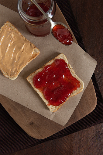 Grilled peanut butter and strawberry  jelly sandwich on a rustic background