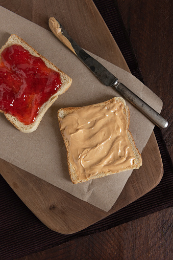 Grilled peanut butter and strawberry  jelly sandwich on a rustic background