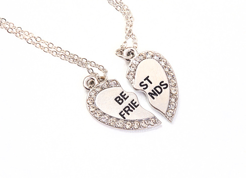 Broken heart best friend necklace, in silver on white background and copy space. the 1990's coming in vast