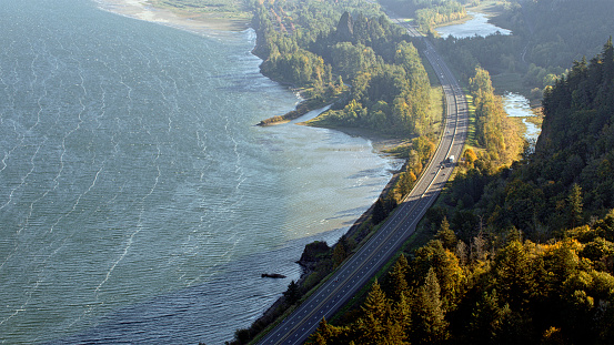 Aerial view of vehicles driving on Vietnam Veterans Memorial Highway along Columbia River on sunny day, Oregon, USA.