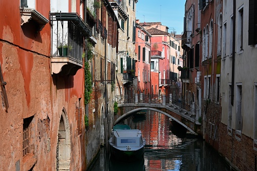 Small canal in Venice with a bridge and a moored boat
