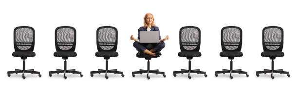 istock Many emtpy office chairs and woman with a laptop meditating 2137452122