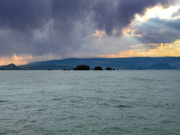 Witness nature's captivating spectacle, where the serene beach meets the tumultuous skies in a harmonious display of contrast and tranquility.