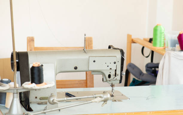 istock Industrial sewing machine with colorful thread, working place, manufacture for clothes, handmade, small local business 2137475145