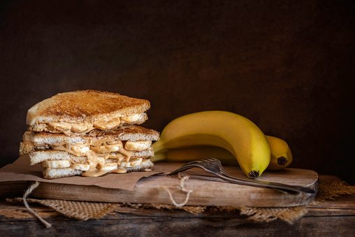 Peanut butter and banana sandwich on a rustic bacground
