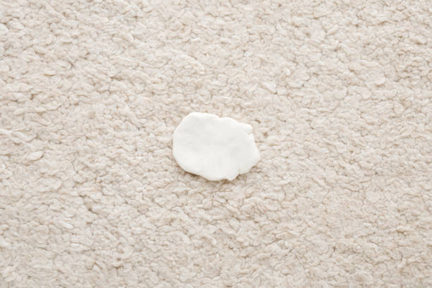 White chewing gum on light beige home carpet. Closeup. Top down view.