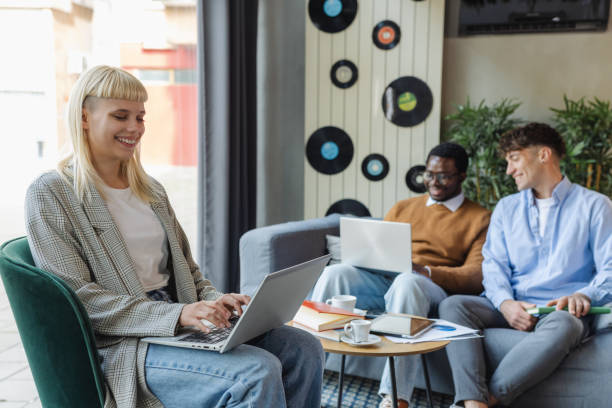 istock Young woman using laptop in modern co-working space 2137487285