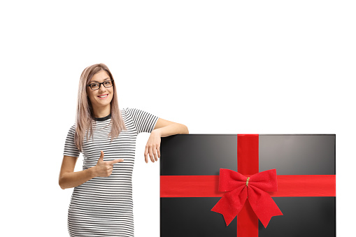 Young woman pointing at a tv flat hd screen tied with a red ribbon isolated on white background