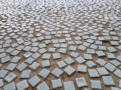The surface of a street wall decorated with small square ceramic tiles