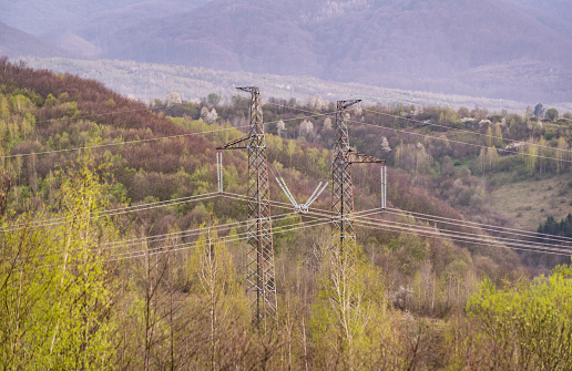 High voltage power lines in rural mountainous area in spring