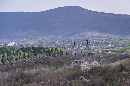 High voltage power lines in rural mountainous area in spring