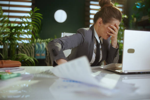 istock sad woman worker in green office throwing documents 2137546769