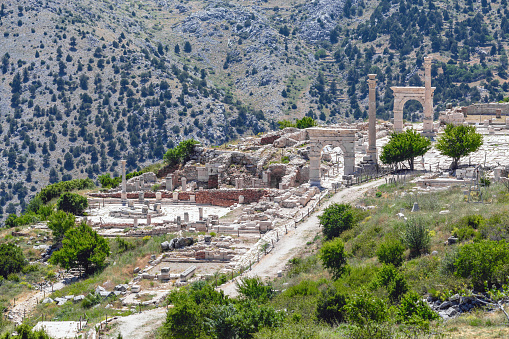 Ancient city ruins, Sagalassos, stone columns, arches, pathways, nestled in mountains. Aerial view. Sagalassos, Aglasun, Turkey (Turkiye)