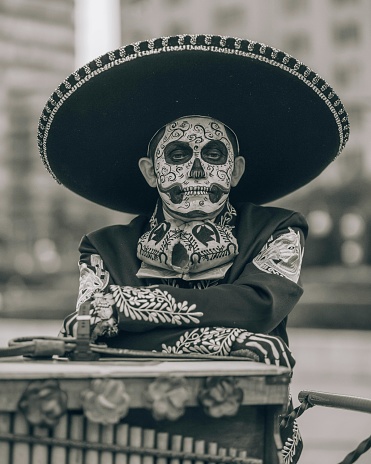 Monterrey, Mexico – November 02, 2023: A monochrome shot of a sad man in a Day of the Dead outfit