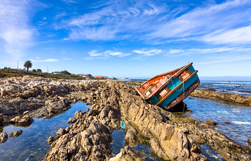 Shipwrecked diamond mining vessel on rocky shoreline in small West Coast town of Port Nolloth, South Africa