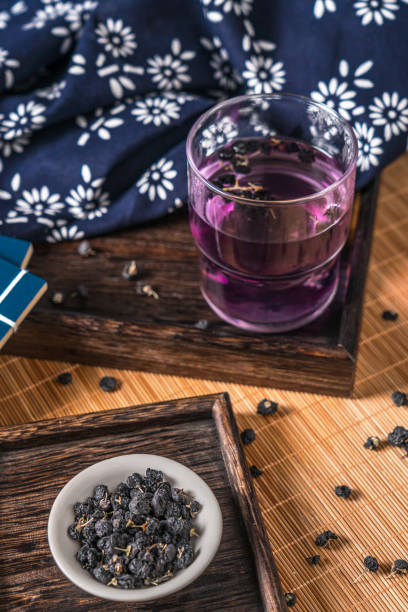 health and wellness foods: black goji berries and black goji berry tea - variation bamboo black bowl zdjęcia i obrazy z banku zdjęć