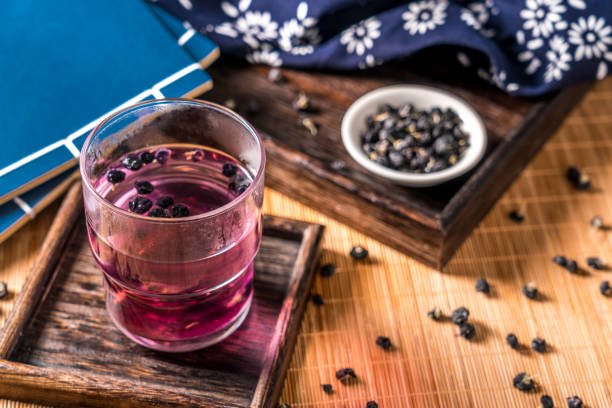 health and wellness foods: black goji berries and black goji berry tea - variation bamboo black bowl zdjęcia i obrazy z banku zdjęć