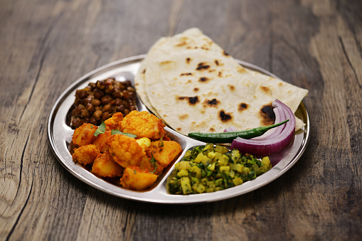 Indian style vegetarian plate. kala chana masala, aloo gobi ki sabzi, mooli ki sabzi and chapati.