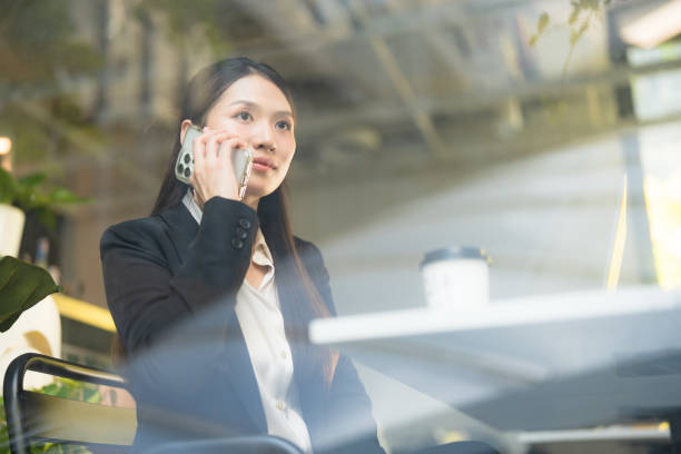 istock Businesswoman communicating on smartphone in cafe 2137653685