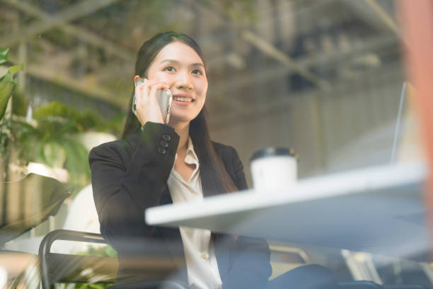 istock Businesswoman communicating on smartphone in cafe 2137654190