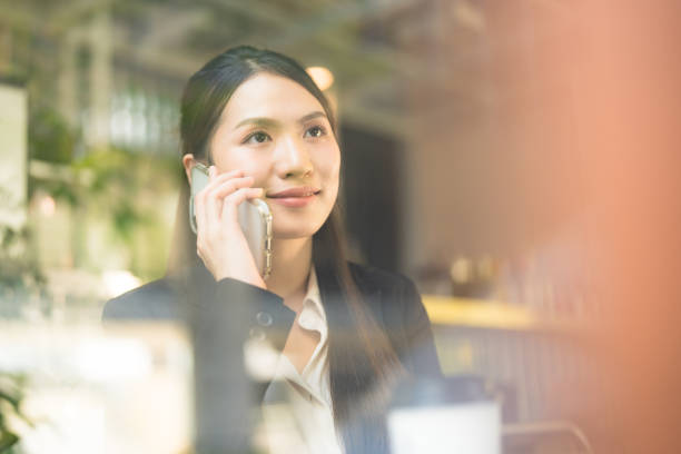 istock Businesswoman communicating on smartphone in cafe 2137654193