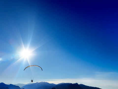 Parachuting over sunny sky