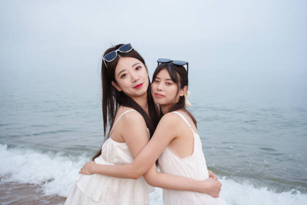 Smiling girlfriends spending time on the beach in surf suit