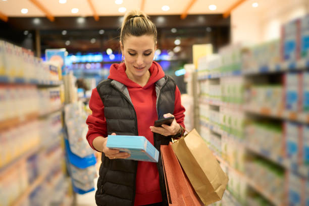 istock A woman interacts on her phone while walking down a shopping store aisle 2137685162