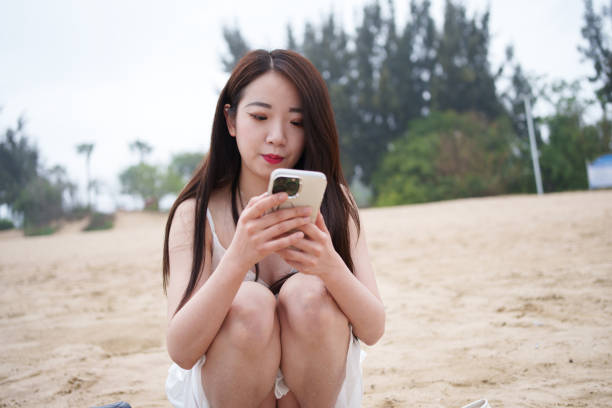 istock Asian woman looking at mobile phone 2137726419