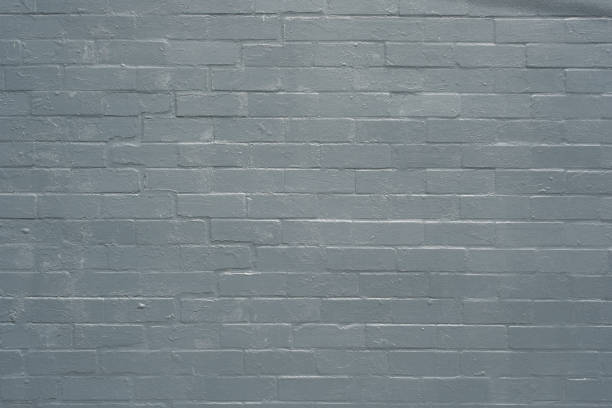 Section of an old brick wall painted gray.