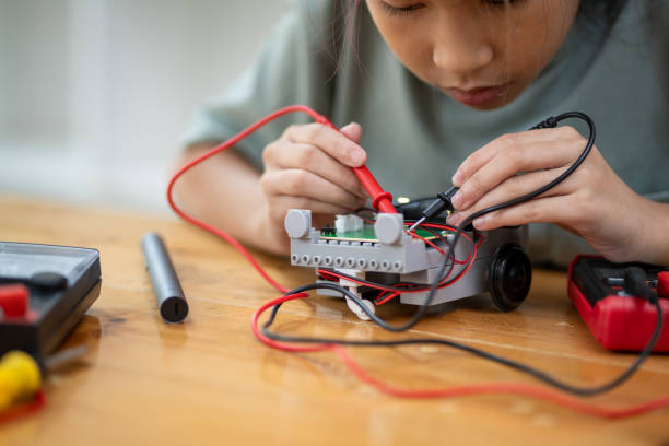 istock Close-up of smart girl using small tools to assemble robot by learning from tablet computer, technology concept 2137783917