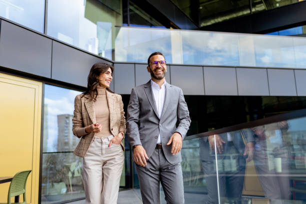 istock Cheerful Colleagues Exiting a Modern Office Building on a Bright Afternoon 2137800136