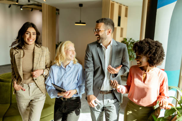 istock Collaborative team walks through the modern office space, sharing ideas and laughter 2137800148