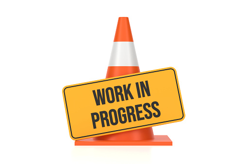 Traffic Cone And Work in Progress Sign On White Background